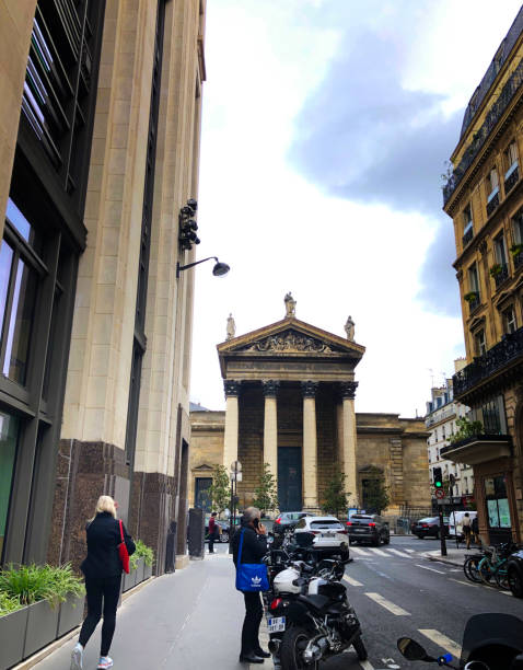 paris, france: woman walks toward notre dame de lorette church - notre dame de lorette imagens e fotografias de stock