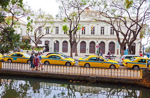 Funchal, Portugal - June 14, 2013: Row of Yellow Taxi Cabs near Jardim Municipal in Funchal city, capital of Madeira island, Portugal