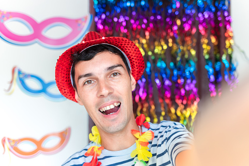 Joyful Brazilian man capturing a selfie in a vibrant carnival setting
