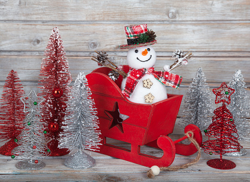 Christmas decorative snowman on white rustic wooden background.