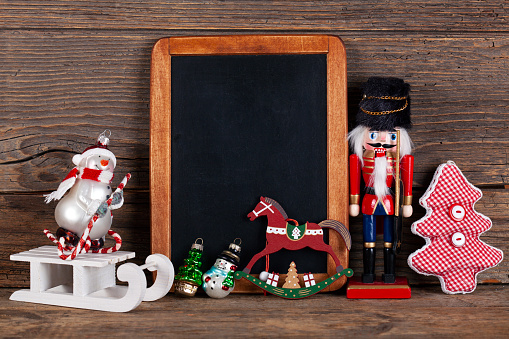 Blackboard with Christmas decoration on wood over rustic background with copy space for text
