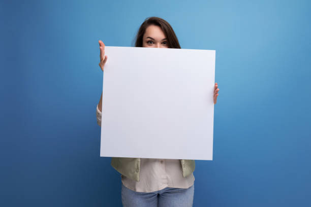 istock young brunette woman demonstrating a paper board with mockup 1836180786