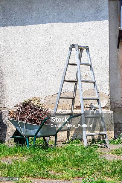 Metal Ladder Y Una Carretilla Por La Vieja Pared Foto de stock y más banco de imágenes de Agricultura - Agricultura, Carretilla, Fotografía - Imágenes