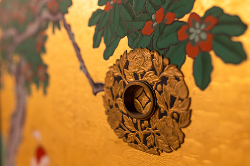 Ornate Japanese gold decorations of a traditional sliding door close up view.