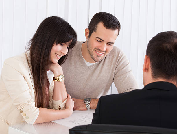 istock Happy Young Couple Discussing With Consultant 183623304