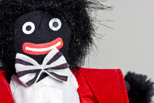 A close up of a retro gollywog doll with bow-tie