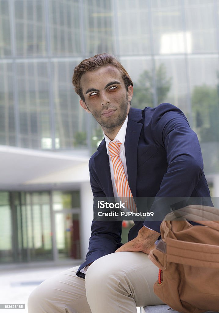 Young vampire businessman outside office with backpack Young vampire businessman outside office with backpack in summer has finished his day work and looking away Finance Stock Photo