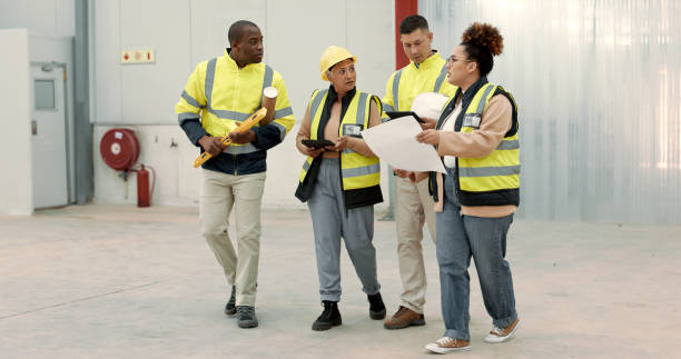 istock Construction site, blueprint and business people walking in a building planning, discussion or renovation idea. Architecture, project management and engineer team in warehouse for design conversation 1836329321