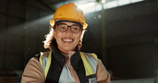 femme heureuse, portrait et ingénieur professionnel dans l’entrepôt pour l’entretien ou la construction. visage d’une femme, d’un architecte ou d’un entrepreneur souriant dans un casque de sécurité pour la gestion des bâtiments industriels - building contractor flash photos et images de collection