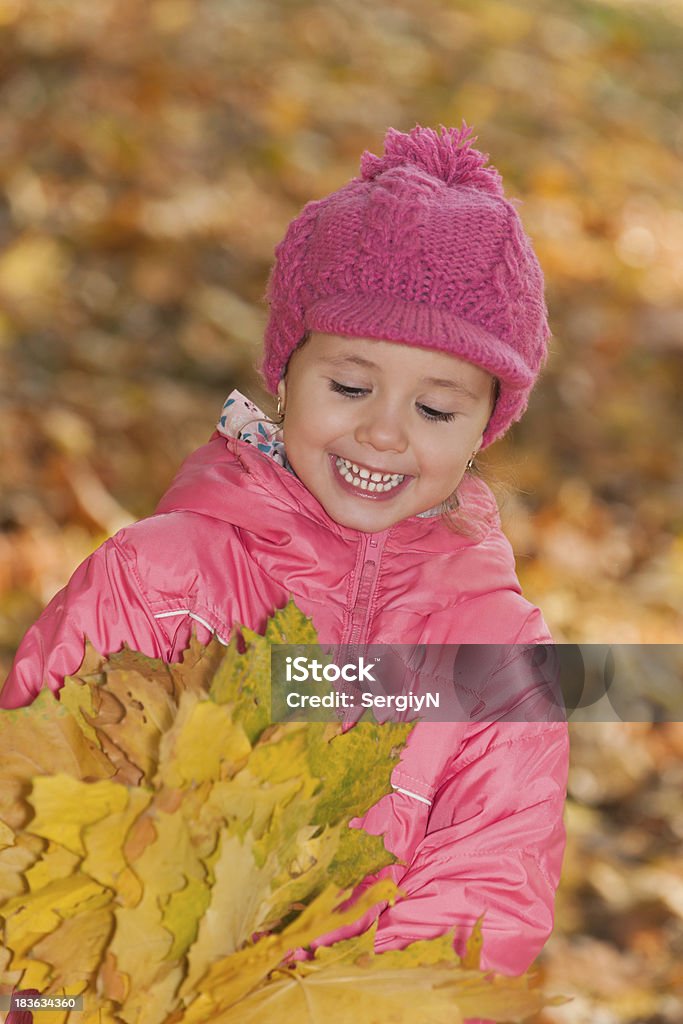 Bambina con foglie gialle - Foto stock royalty-free di 4-5 anni