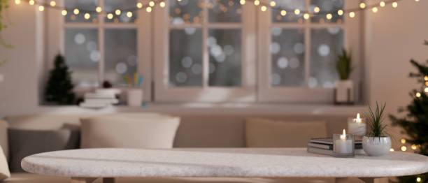 Empty mockup space on a white marble coffee table in a modern, cosy festive living room on Christmas