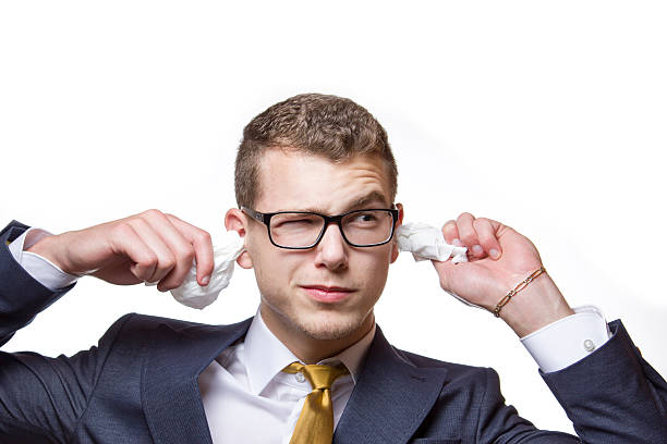 Young businessman cleaning his ears with a cotton tissue stock photo