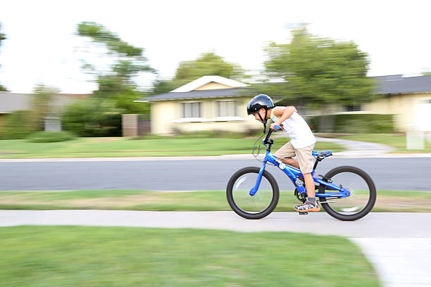 garçon sur son vélo dans le quartier de passer - ten speed bicycle photos et images de collection