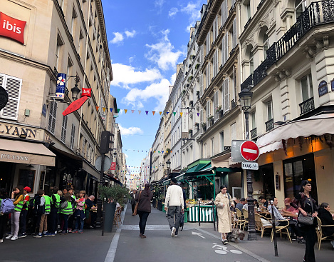 Paris, France: A crowd of people—including schoolchildren—on the Rue Cadet, a narrow pedestrian-only street. Situated in the 9th arrondissement, the street is known for its food shops and outdoor markets.