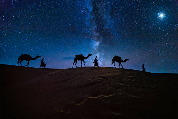 Three Wise Men, Three Kings follow Bethlehem star in the night Christmas Jesus birth concept - Adoration of the Magi, Three Wise Men, Three Kings, and the Three biblical Magi with camel silhouettes journeying in sand dunes of desert follow Bethlehem star at night camel train stock pictures, royalty-free photos & images