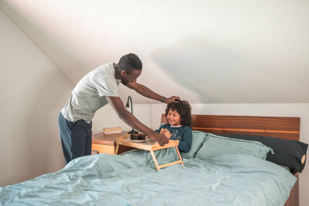 istock Cute African Boy With Curly Hair Happy About Getting Breakfast in Bed 1836446074