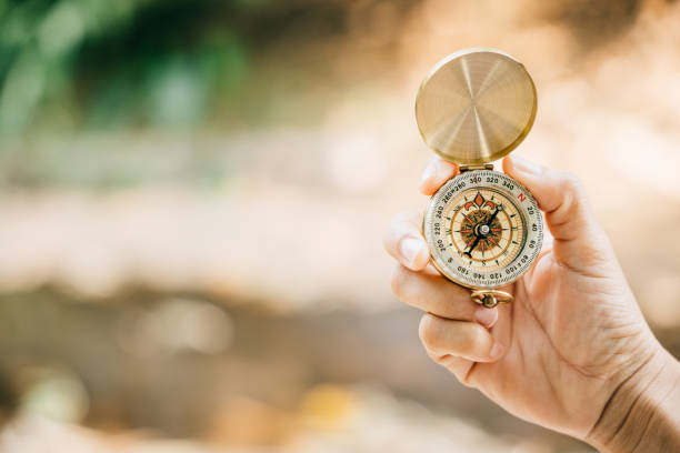 istock Amidst the picturesque forest and serene lake a woman's hand securely holds a compass epitomizing guidance and the adventurous exploration that awaits in the great outdoors. 1836456659