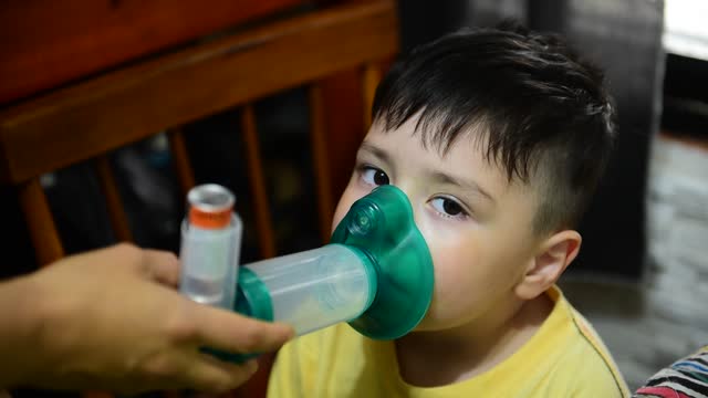Pneumonia concept. Child using an aerial camera with salbutamol. Asthma concept. Pneumonia concept. Respiratory dilator. Video.