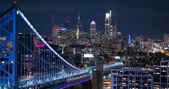 Aerial still image of Benjamin Franklin Bridge with the Philadelphia skyline in the background, on an overcast night in Fall.\n\nAuthorization was obtained from the FAA for this operation in restricted airspace.