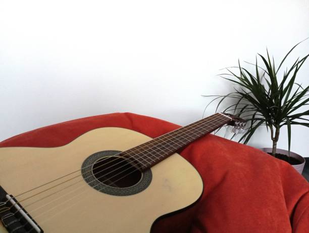 istock A classic six-string guitar rests on a red bean bag chair in the room. 1836554166