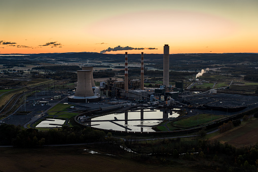 Drone shot of a coal fired power plant surrounded by farmland in Montour County, Pennsylvania before sunrise on a clear morning in Fall.