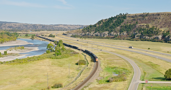 Aerial view of freight train in Greycliff, a census-designated place in Sweet Grass County, Montana, on a slightly cloudy day in Fall.