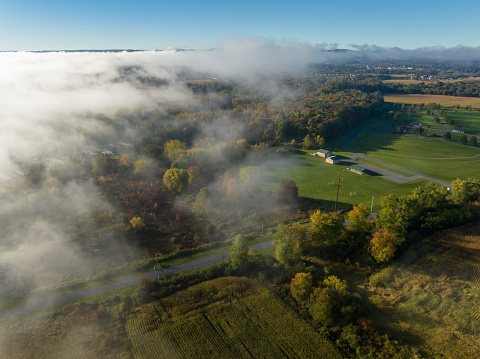Aerial shot of rural scenery in Lycoming County, Pennsylvania, between the towns of Muncy and Pennsdale, on a misty morning in Fall.