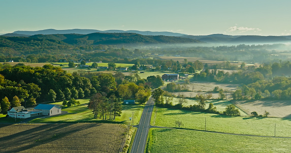 Aerial shot of rural scenery in Lycoming County, Pennsylvania, between the towns of Muncy and Pennsdale, on a hazy morning in Fall.