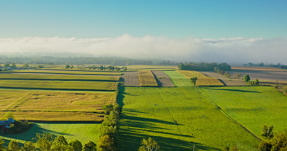 Aerial shot of rural scenery in Lycoming County, Pennsylvania, between the towns of Muncy and Pennsdale, on a hazy morning in Fall.