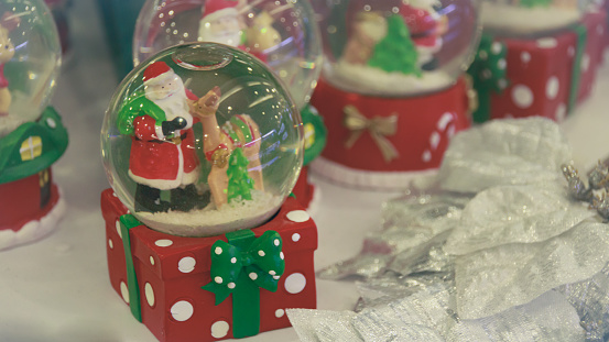 Snow globes featuring Santa Claus and a reindeer, seasonal Christmas decorations