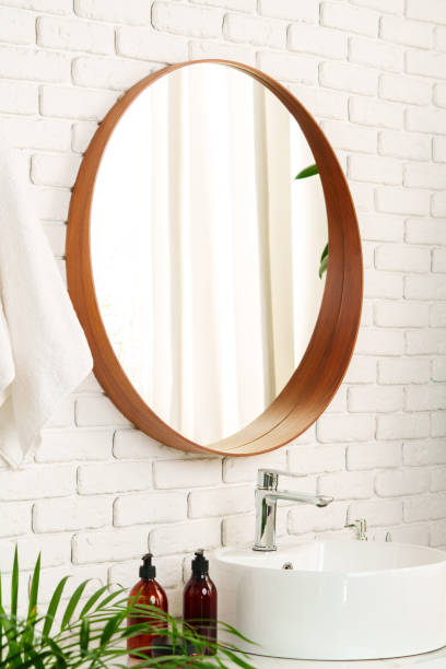 istock Bathroom interior with circle shaped mirror in wooden frame and white sink 1836718265