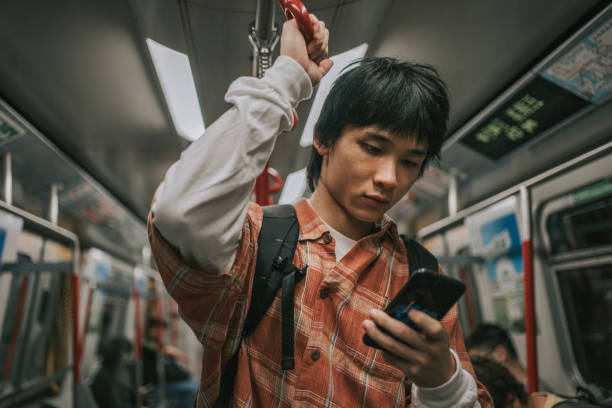 istock Asian Chinese young man phone messaging in subway train 1836742431