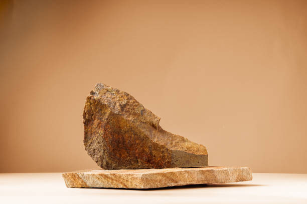 istock Piece of granite stone against beige background with shadows 1836767473