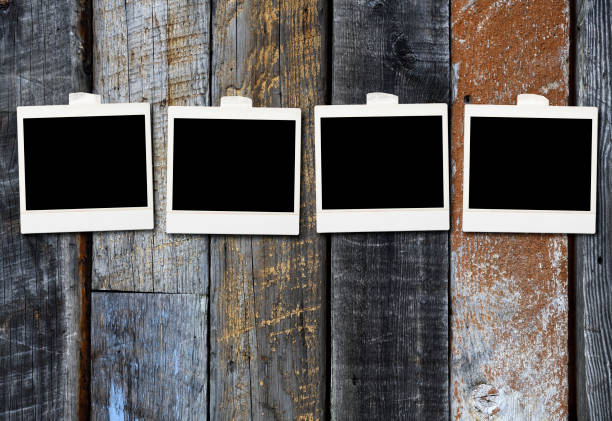 istock Lined up blank photos attached on an old wooden wall 1836788771