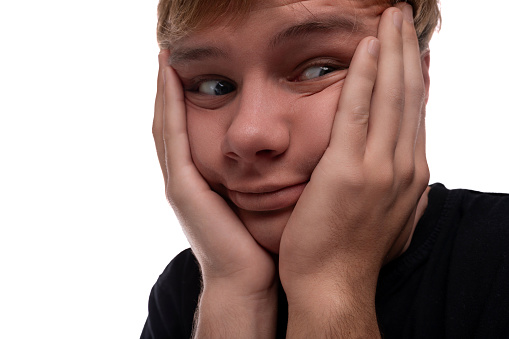 Portrait of a teenage guy with blond hair having problems.