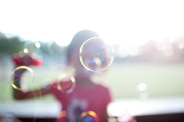 little asian girl playing bubble in park