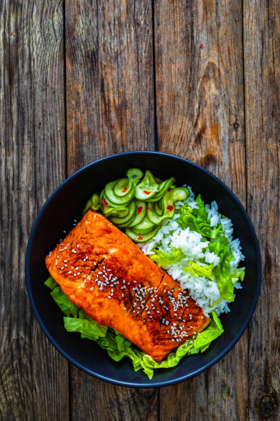 istock Seared teriyaki salmon steak with white rice on wooden table 1836836249