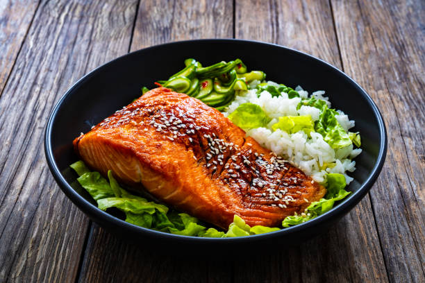 istock Seared teriyaki salmon steak with white rice on wooden table 1836837265
