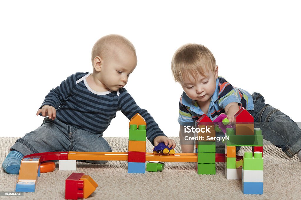 Están jugando con dos niños bebés - Foto de stock de 12-23 meses libre de derechos