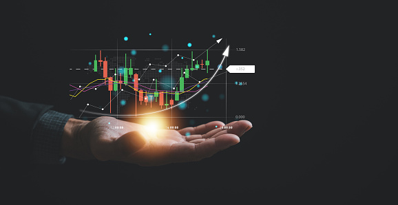 Navigating the complexities of the stock market, a trader or investor relies on a palm-sized device, examining candlestick charts and employing cutting-edge tools to optimize their trading strategies.