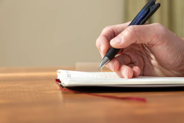 istock Side view of the hands of a person taking notes in a notebook 1836876608