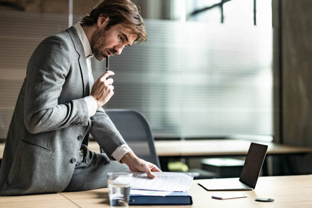 istock Young businessman going through paperwork in the office. 1836883103