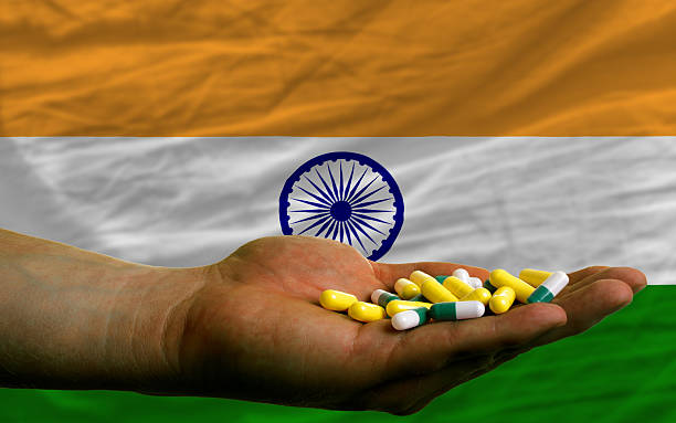 holding pills in hand front of india national flag stock photo
