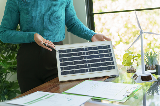 Solar panels green energy Business people working in green eco friendly office business meeting creative ideas for business eco friendly professional teaching corporate people sustainable electricity.