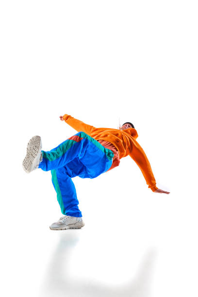 istock Stylishly dressed man, guy, professional dancer performing freestyle, breakdance freezes, flexing against white background. 1836939840