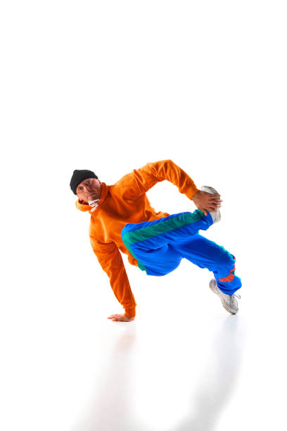 istock Stylishly dressed man, guy, professional dancer training breakdance freezes, flexing in dace hall in motion against white background. 1836940359