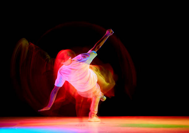 istock Dance show. Athletic guy dancing contemp, breakdance and hip-hop against black studio background in mixed neon light with motion blur. 1836940379