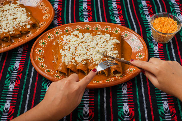 Person eating enchiladas with red pipian. Typical Mexican food.