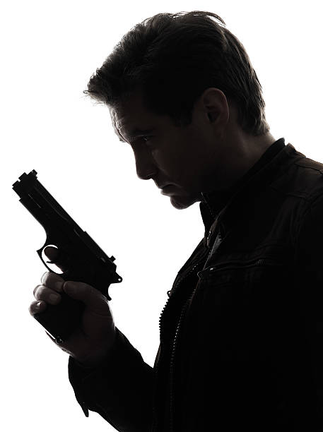Side profile silhouette of man holding gun