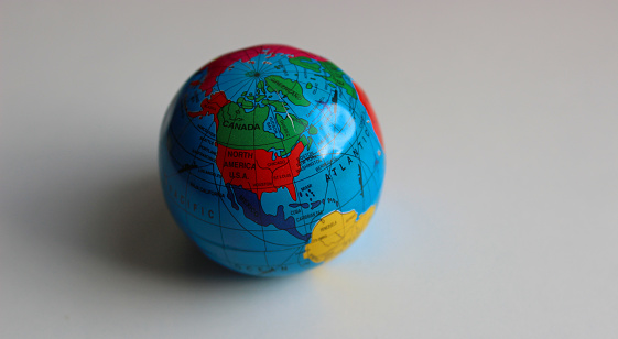 Miniature globe on a white surface with conventionally drawn continents